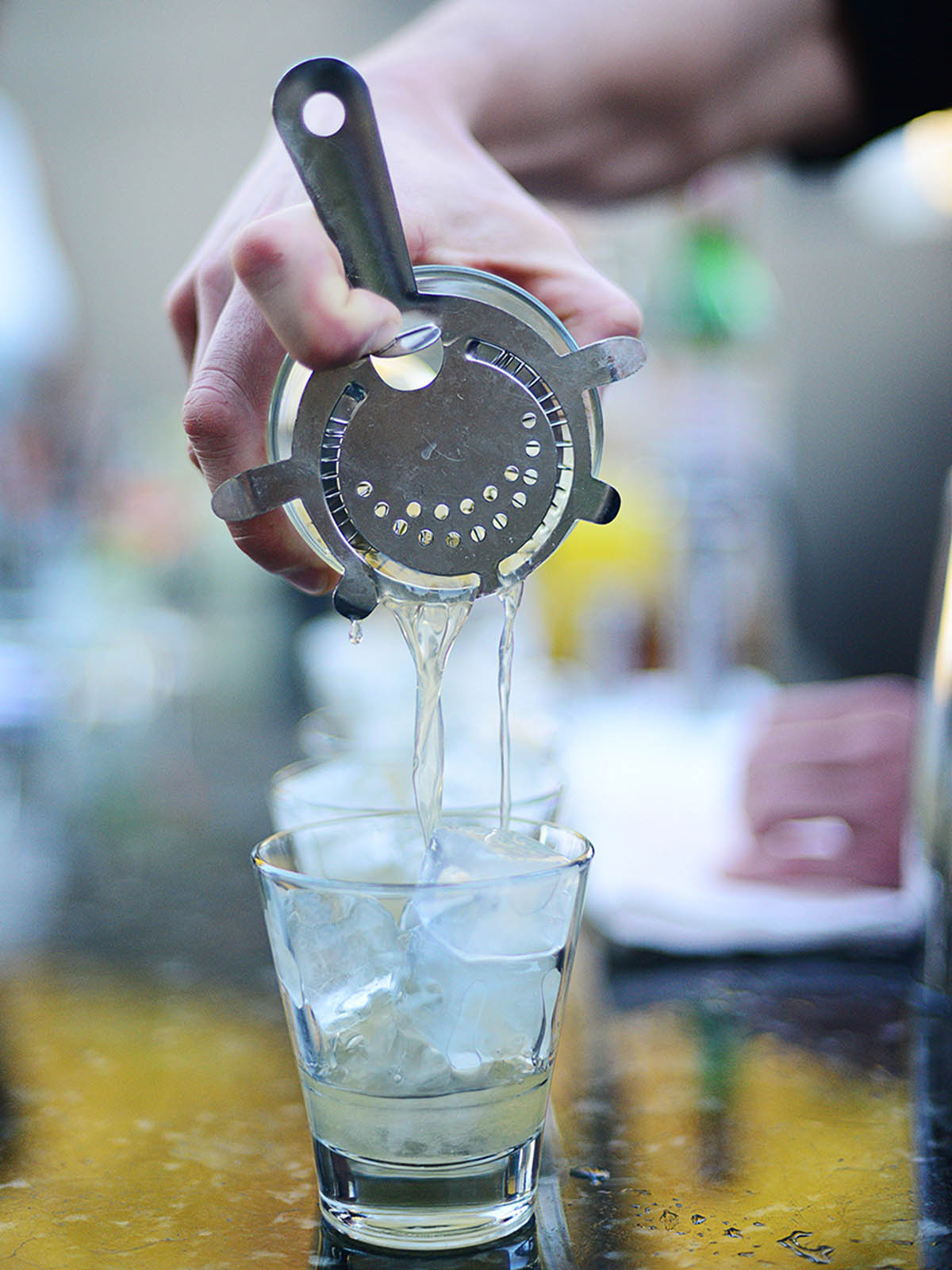 Pouring cocktail mix thru a mixer.