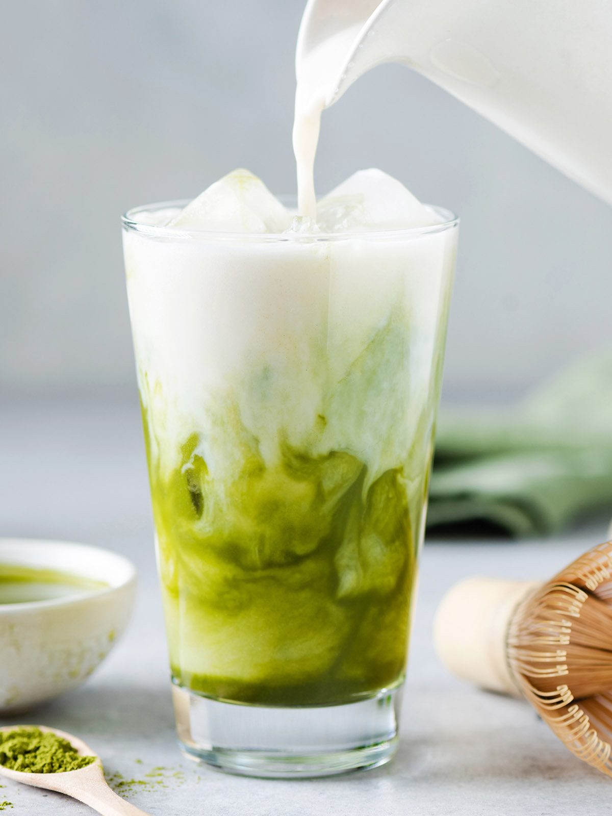 Soy milk pouring in matcha ice tea.