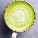 Matcha, green tea latte in a cup. Grey stone background. Top view.