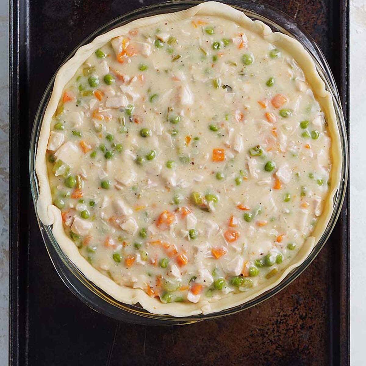 A pot pie container with the pie crust and filling inside.
