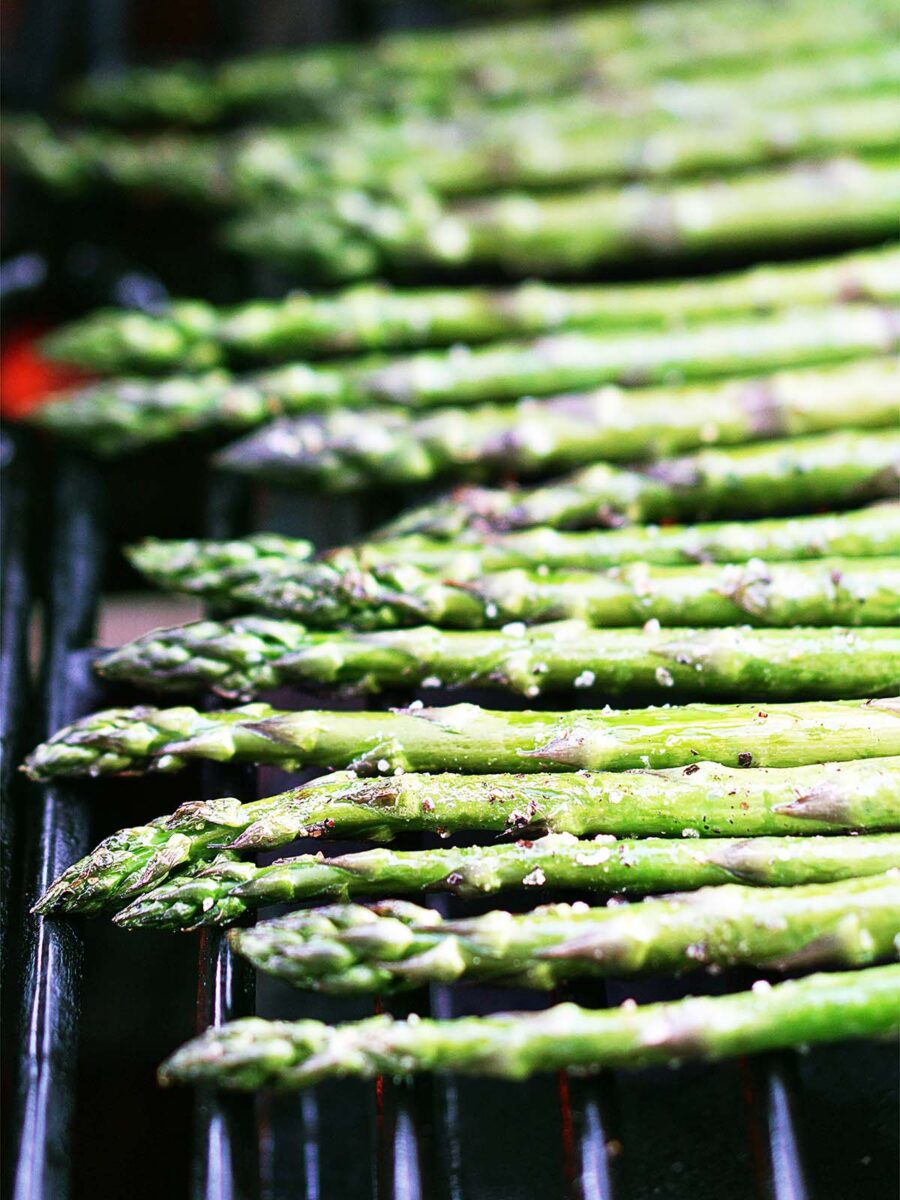 Lined up asparagus on a grill.