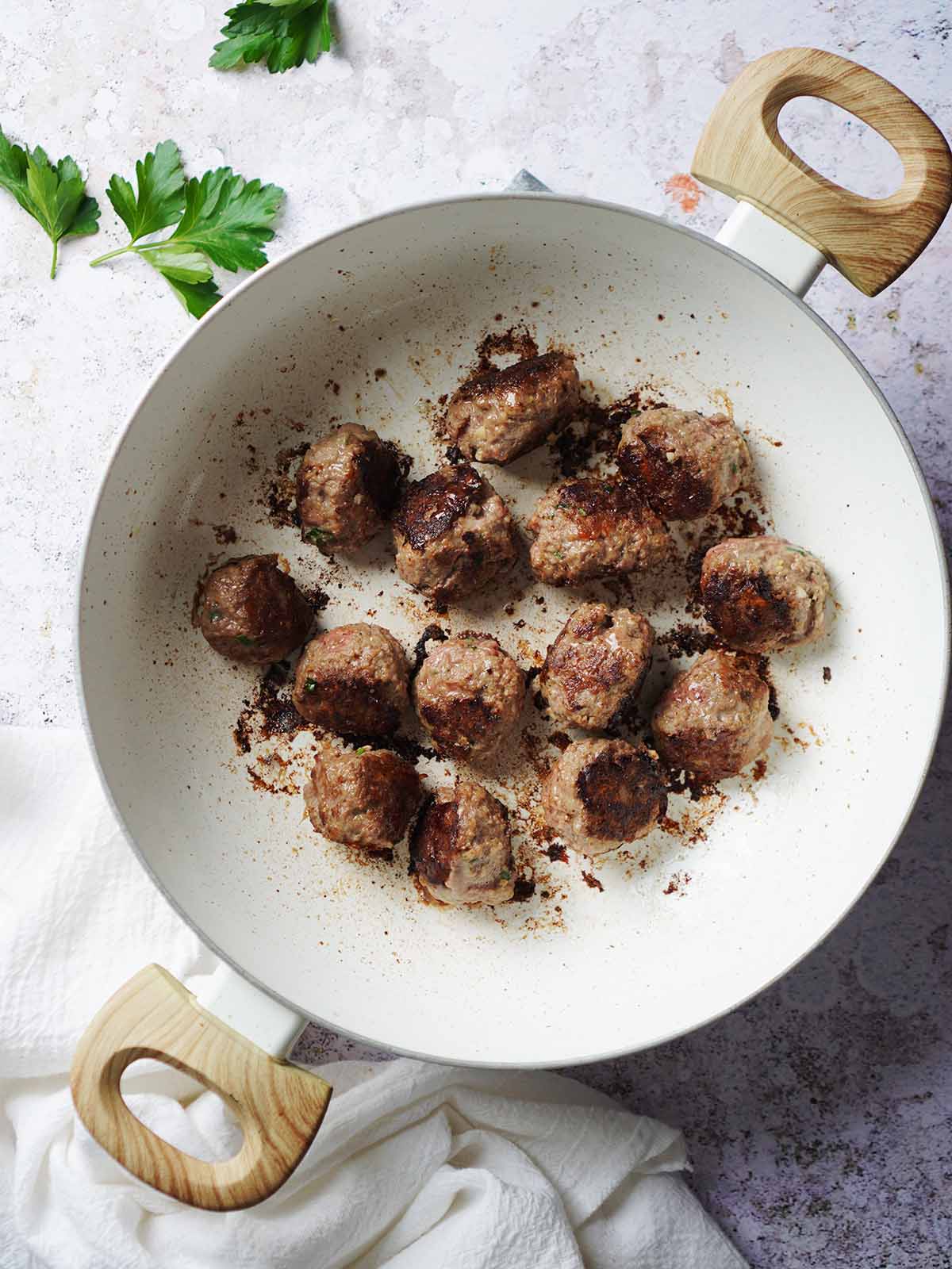 Browning meatballs in a skillet.