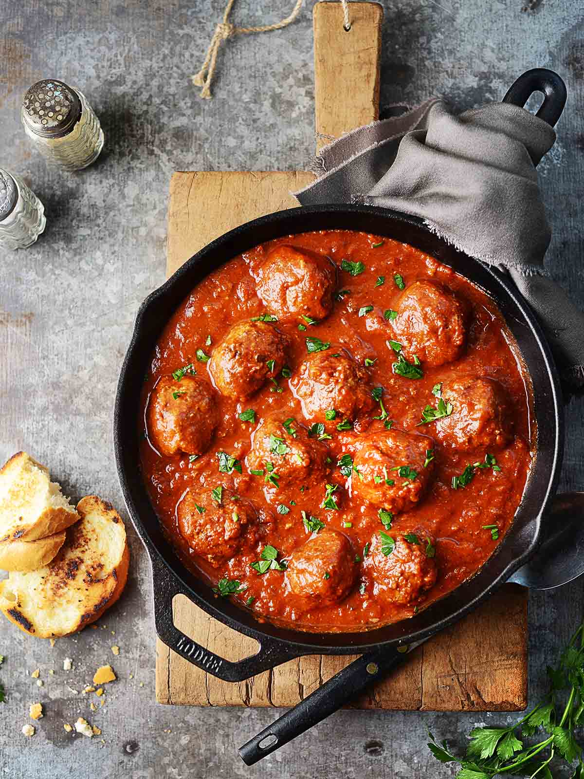 Beef meatballs in a skillet with marinara sauce.