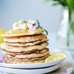 A stack of pancakes on a white plate.