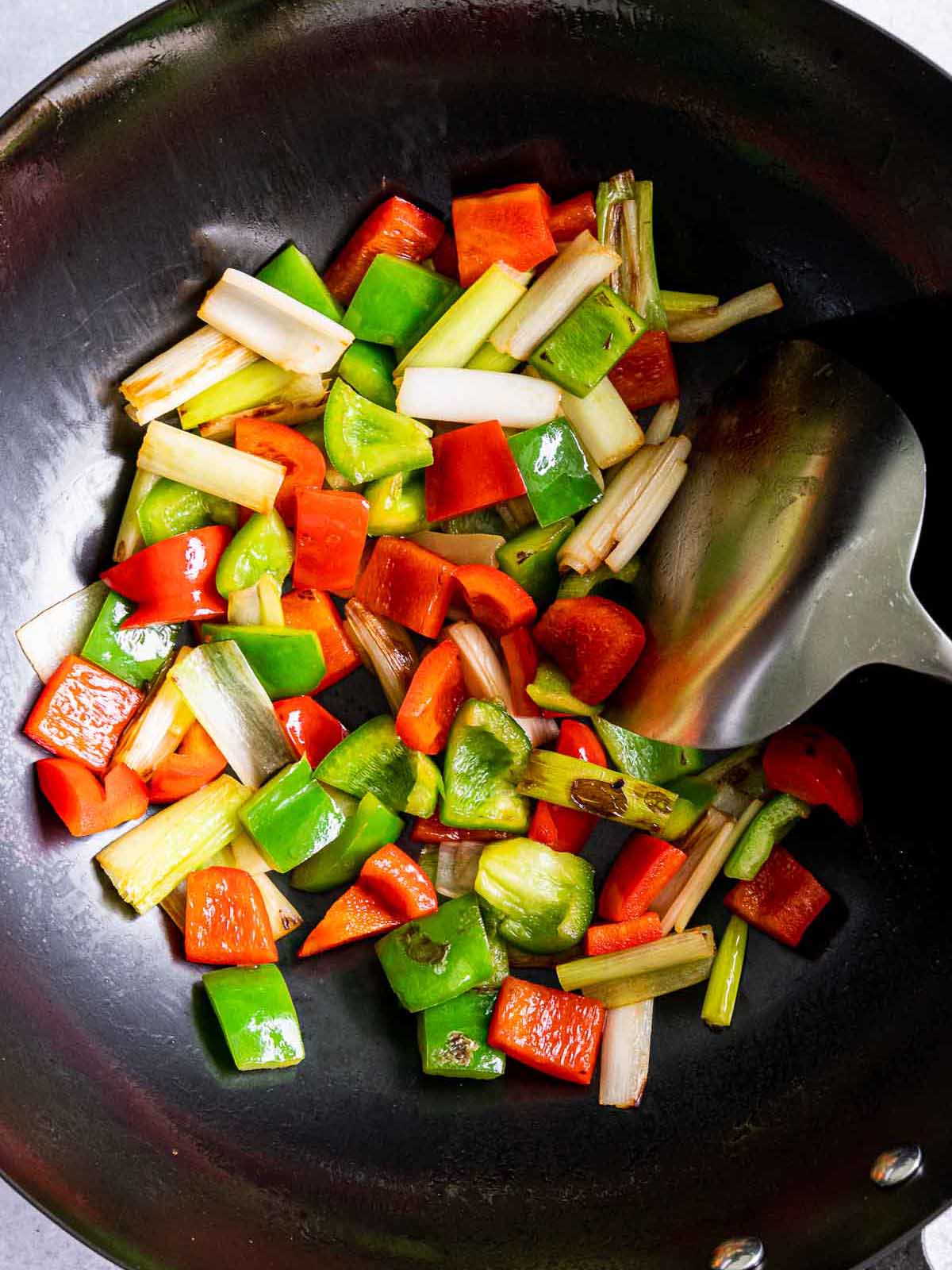 Sauteing the chopped veggies in a wok.