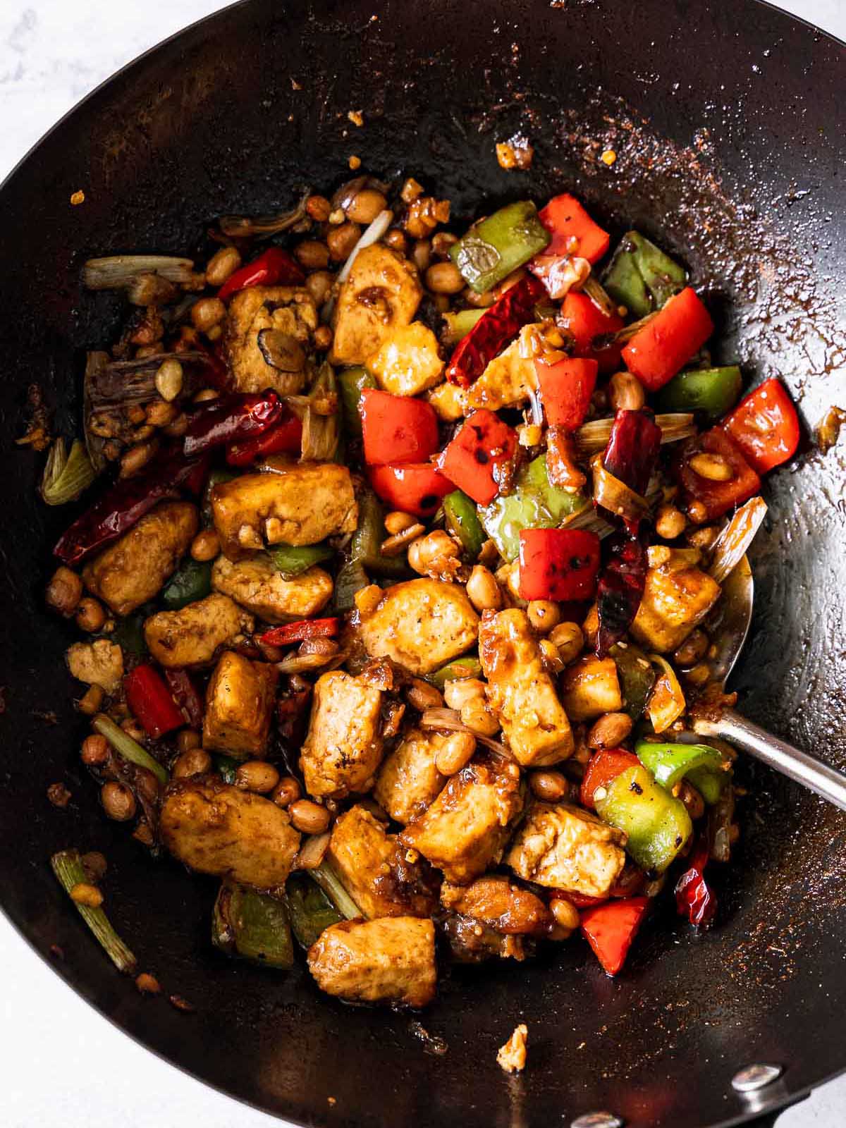 Cooking the pork and veggies in a wok.