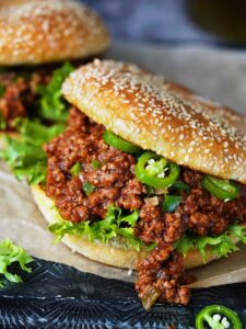 Two sloppy joes sandwiches made with sesame buns.