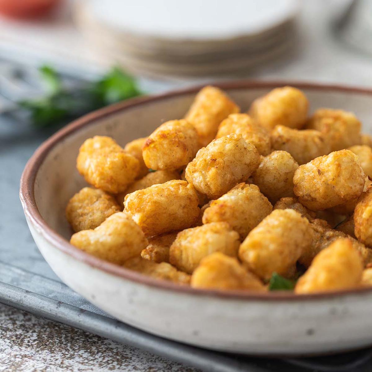 Air fryer Tater tots in a white bowl.