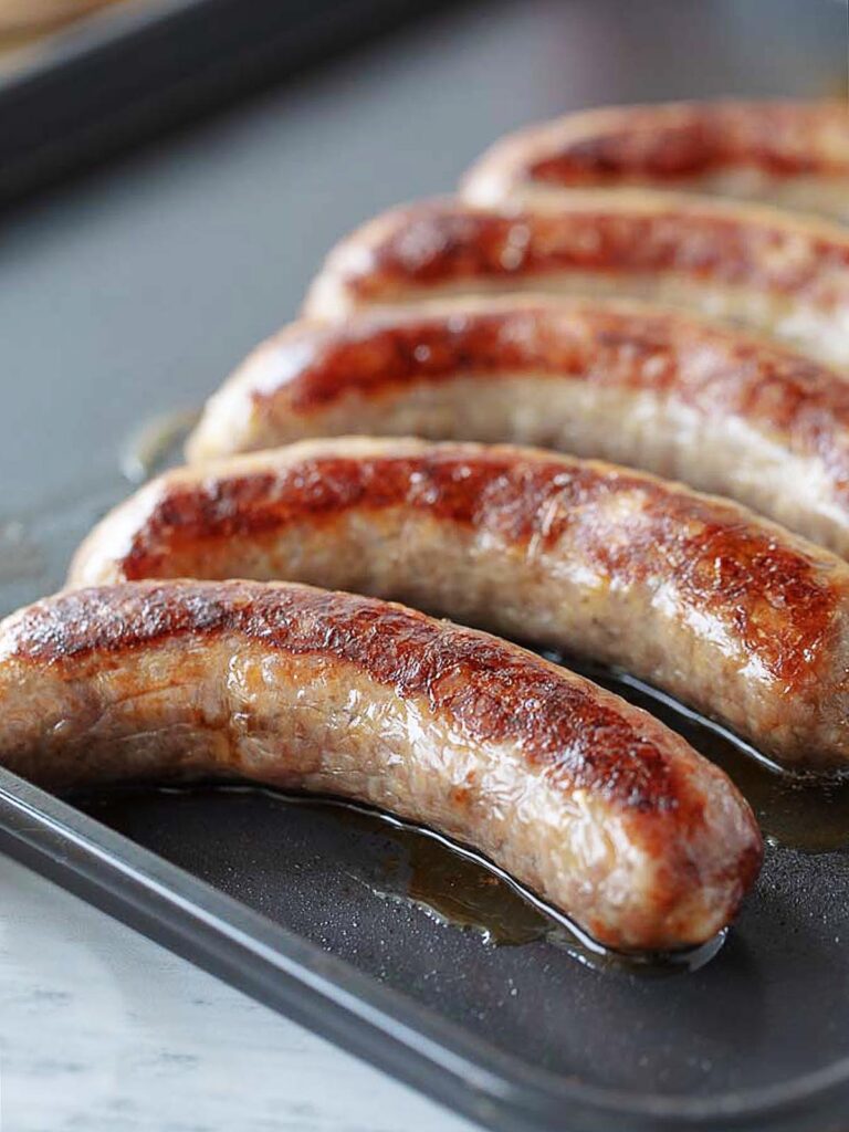 Johnsonville brats on an air fryer tray after cooking.