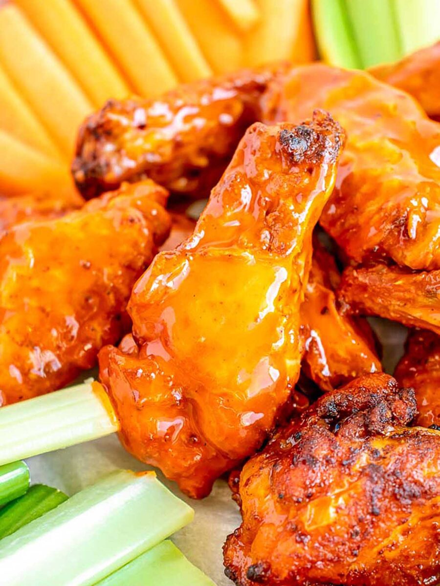Buffalo-style chicken wings served with carrot and celery sticks.