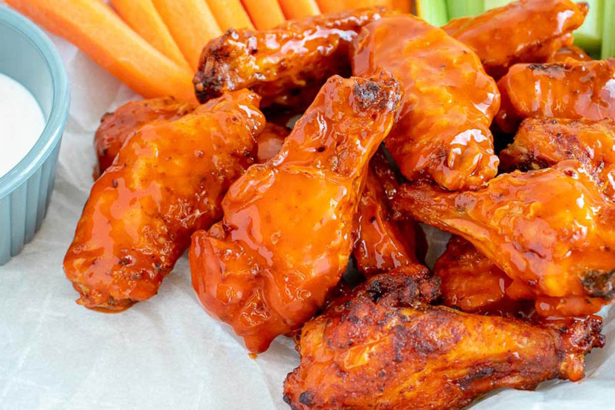 Buffalo-style chicken wings served with carrot and celery sticks.